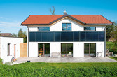 Ein Wohnhaus mit Solarthermie-Fassadenkollektoren als Brüstung