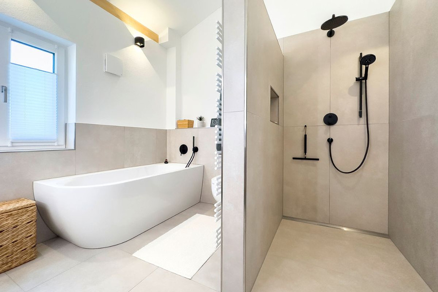 Helles Badezimmer mit Badewanne und freibegehbarer Dusche