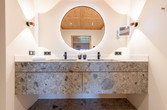 Badezimmer mit Waschtisch aus Naturstein