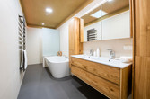 Bad mit Möbeln aus Holz und Badewanne