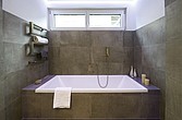 Badewanne im Bad mit Natursteinfliesen