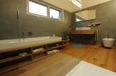 Bad mit Möbeln aus Holz und Badewanne