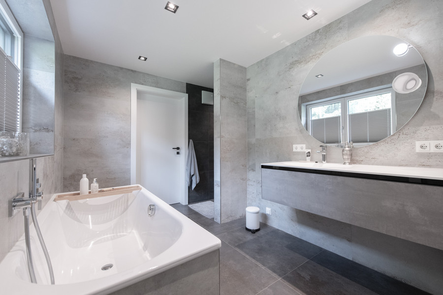 Modernes Komplettbad in Betonoptik mit Badewanne Dusche und großem Waschtisch