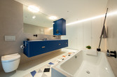 Bad mit Badewanne und blauen Möbeln