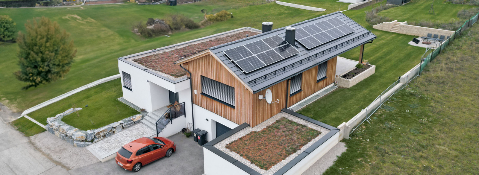 Modernes Wohnhaus, teilweise mit Holzfassade, PV-Anlage auf dem Satteldach