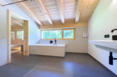 Ein helles, modernes Bad mit Holzdecke und Sauna