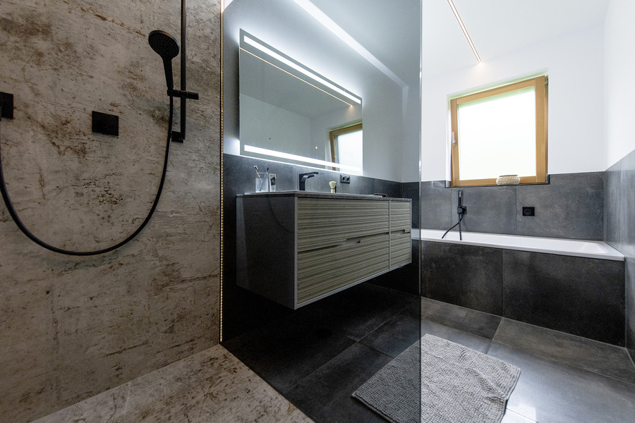 Stylisches Komplettbad mit Duschabtrennung aus getöntem Glas und fugenlosem Duschbereich