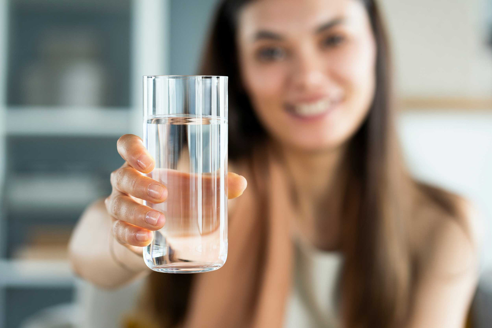 Eine Hand hält ein Glas mit sauberem Trinkwasser
