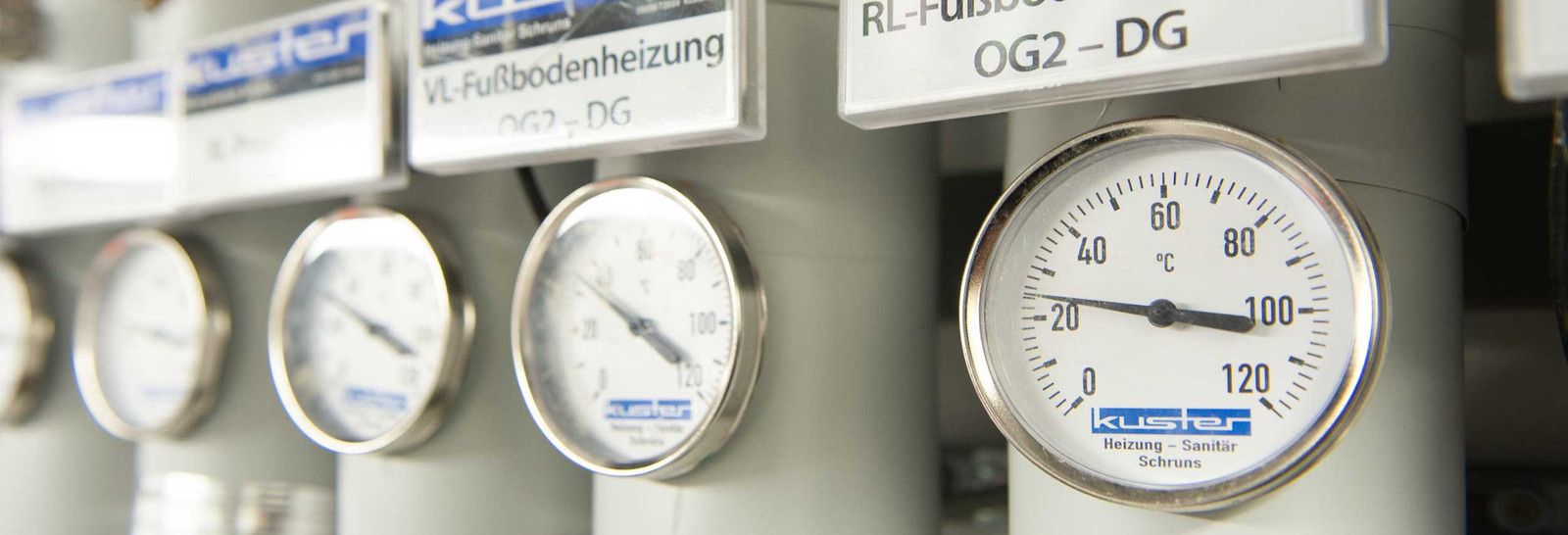 Detailbild Heizungskeller mit Rohren für Wärmeverteilung und Thermometern für Vor- und Rücklauf