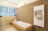 Badezimmer mit Badewanne und Handtuchtrockner