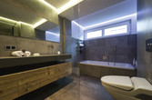 Badezimmer mit hintergrundbeleuchtetem Spiegel