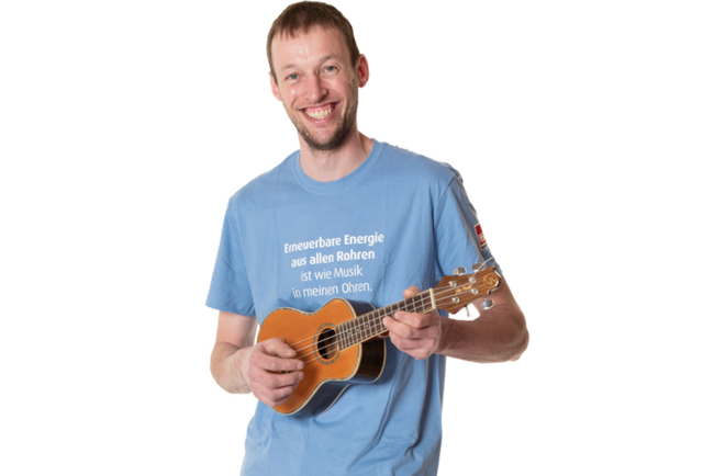 Ein Mitarbeiter von Intallationen Steiner in einem hellblauen T-Shirt spielt Ukulele