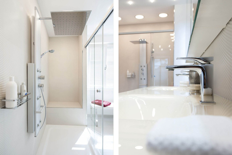 Bodenebene Walk-in-Dusche mit integrierten Sitzbänken und Duschpaneel