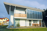 Ein Wohnhaus mit Fassadenkollektoren über der Terrasse