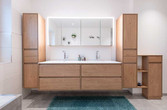 Ein Doppelwaschtisch mit hinterleuchtetem Spiegelschrank und Badmöbeln aus Holz