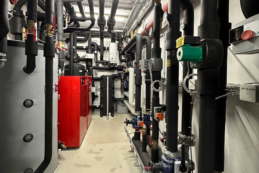 : Der Technikraum mit Pufferspeicher, Wärmepumpen, Leitungen und Lüftungskomponenten