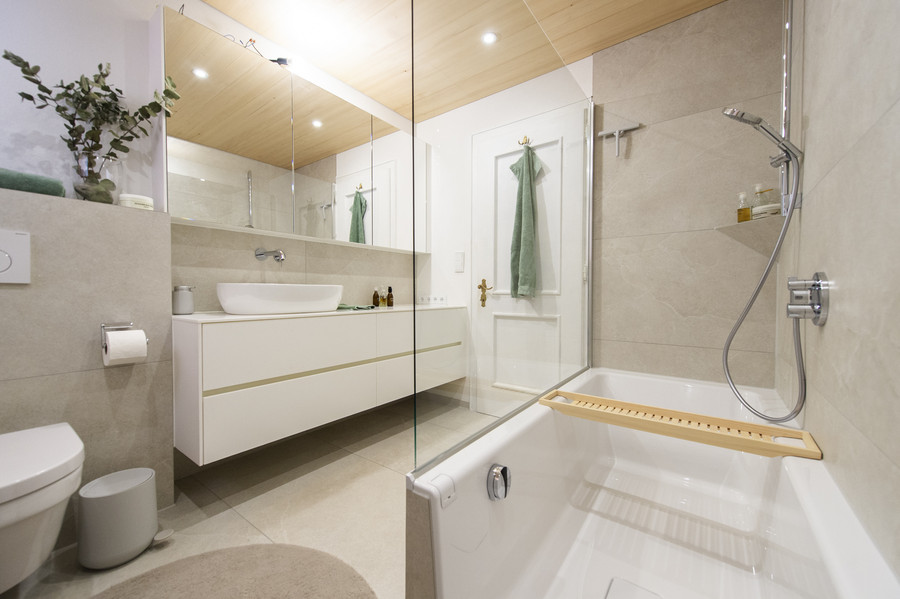 Badezimmer mit Badewannen- und Duschkombi und Waschtisch aus Corian