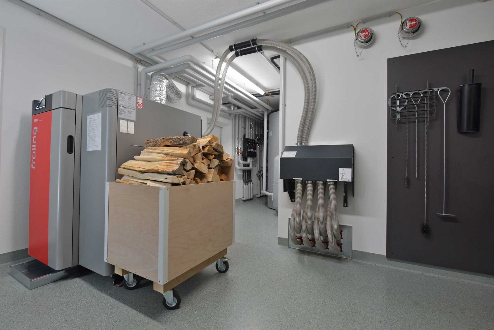 So sieht ein Heizungsraum nach der Heizungssanierung mit Kombikessel und Lagerbehälter für Holz und Pellets aus.