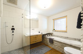 Badezimmer mit Dusche und Badewanne und Abtrennung aus Glas