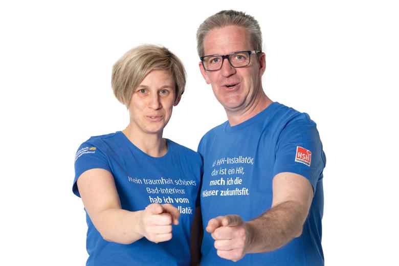 Alexander und Yvonne Apfeltahler tragen blaube Shirts und halten jeweils einen Daumen in die Höhe